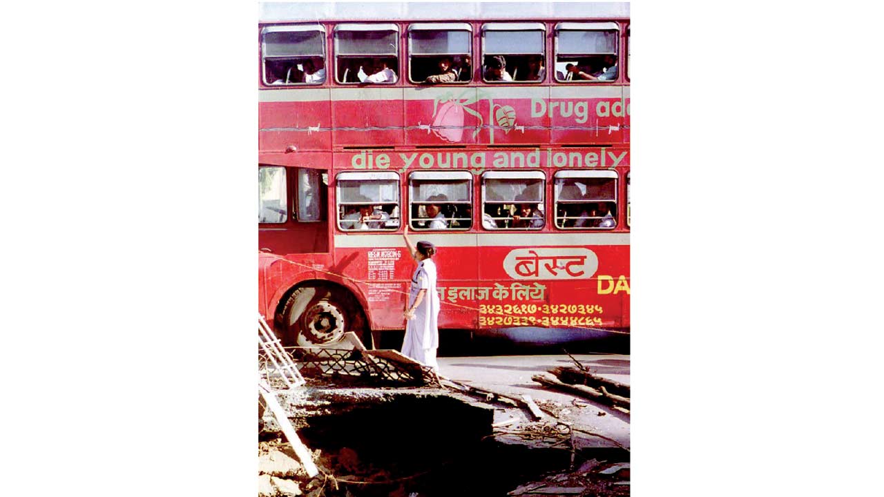 A bus pass a crater caused by a bomb blast, on March 16, 1993. Pic/AFP