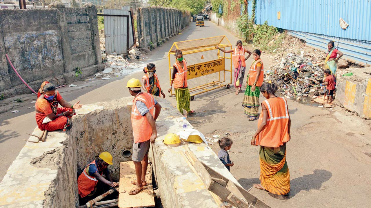 BMC contract workers clean a drainage in Andheri, in April 2021. Pic/Satej Shinde