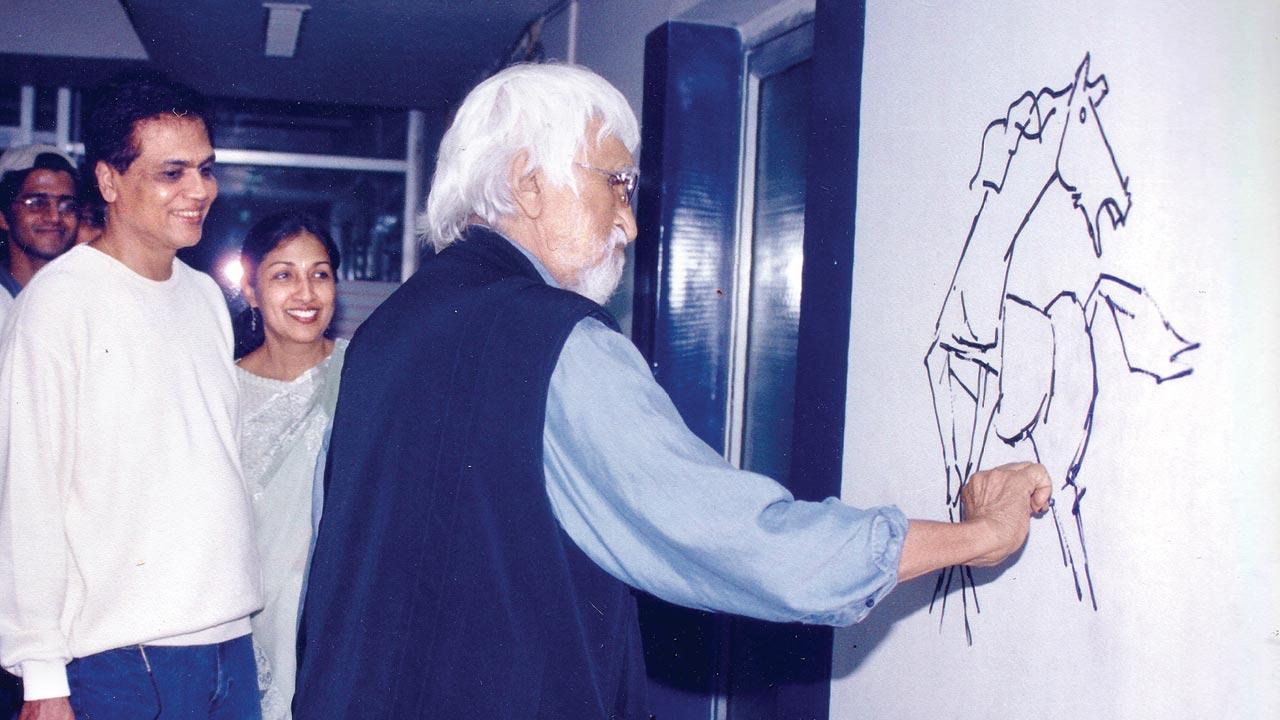 MF Husain sketches on the wall outside the animation studio in 2001, as Arun and Chandralekha Roongta watch 