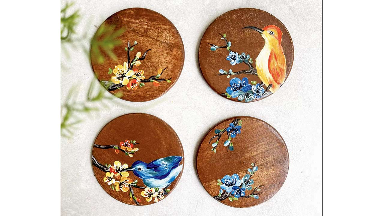 A basket made using water hyacinth by Asama and (right) handpainted hummingbird  wooden coasters by Floursha