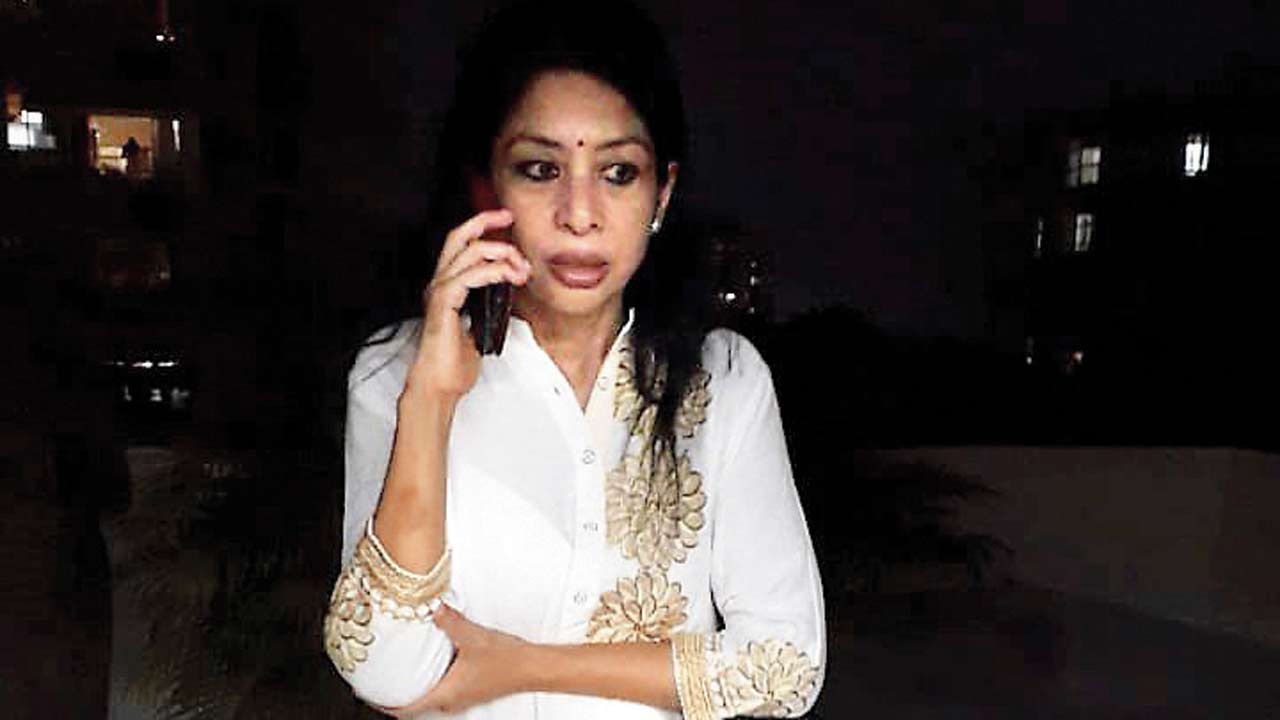 Indrani talks over phone at the terrace of her fifth-floor flat in Marlow building, Worli