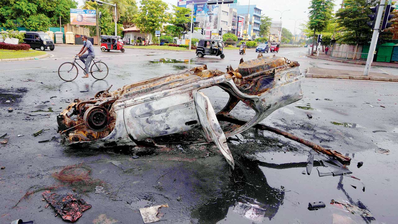 A burnt car at a square a day after govt supporters, anti-govt protesters clashed in Colombo, on Tuesday. Pic/AFP