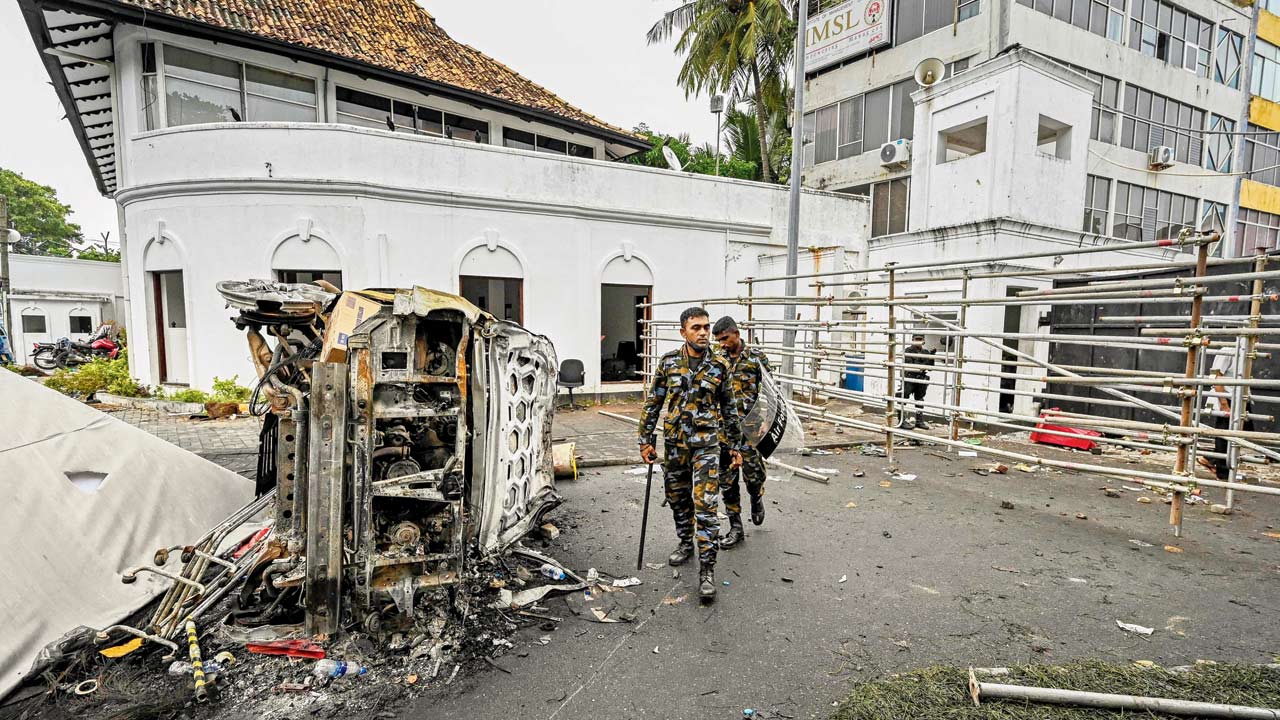 Security personnel near the wreckage of a vehicle that was set afire on Monday, in the capital on Tuesday. PICS/AFP