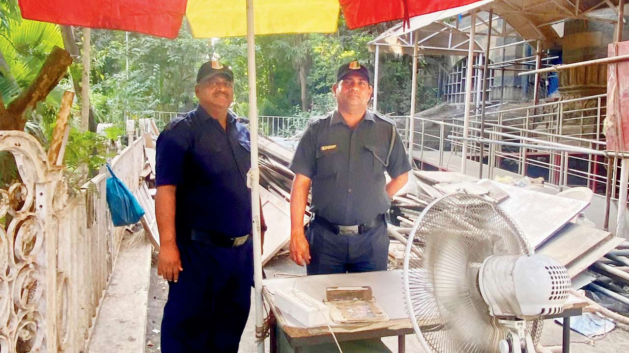 A resting point with an umbrella and a pedestal fan for security staff