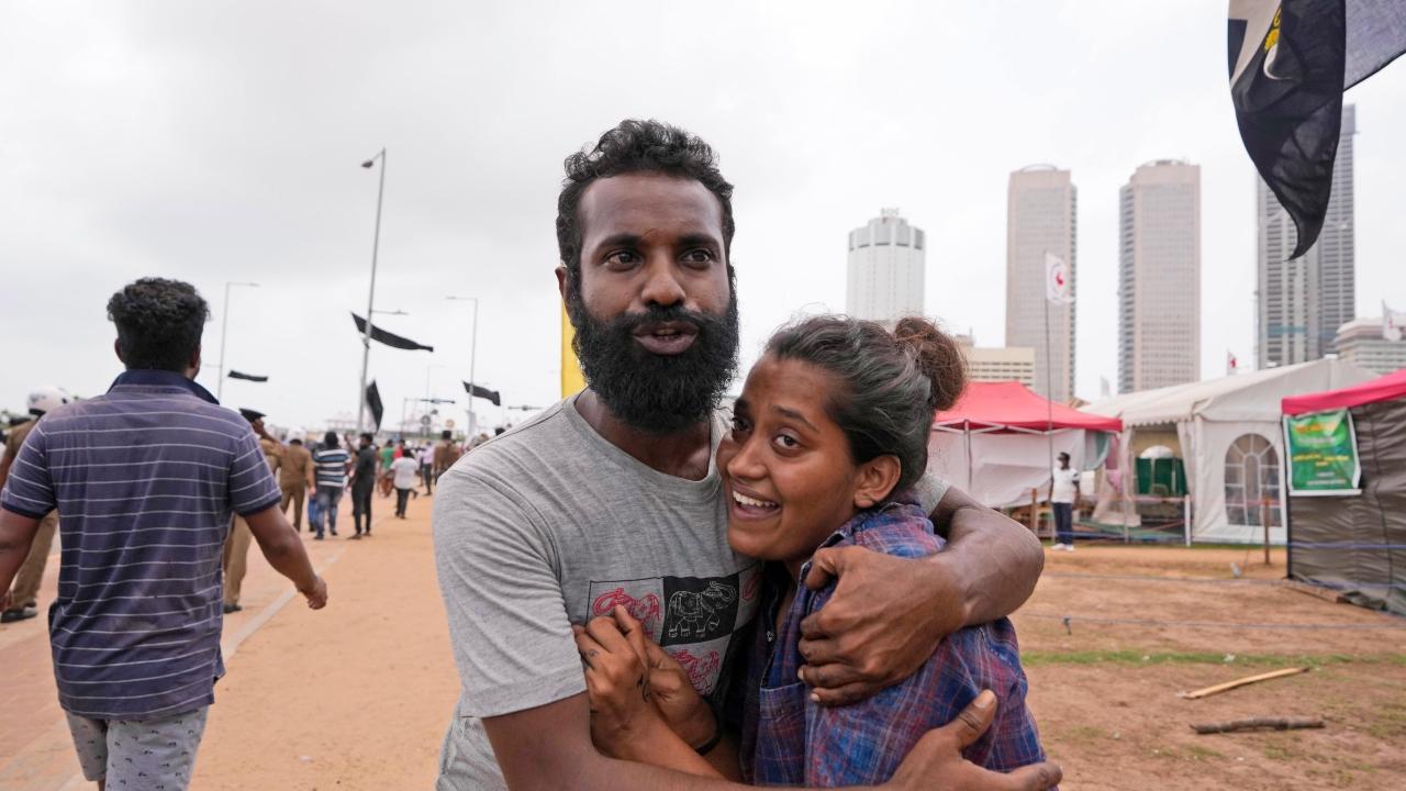 A Sri Lankan anti government protester, left, consoles another during a clash with government supporters in Colombo