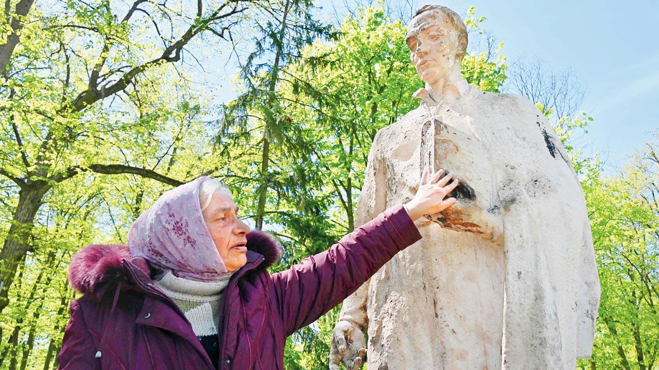 A museum employee touches the sculpture of Ukrainian philosopher Hryhorri Skovoroda, removed from the destroyed Hryhoriy Skovoroda National Literary Memorial Museum in the village of Skovorodynivka, in Kharkiv on Saturday