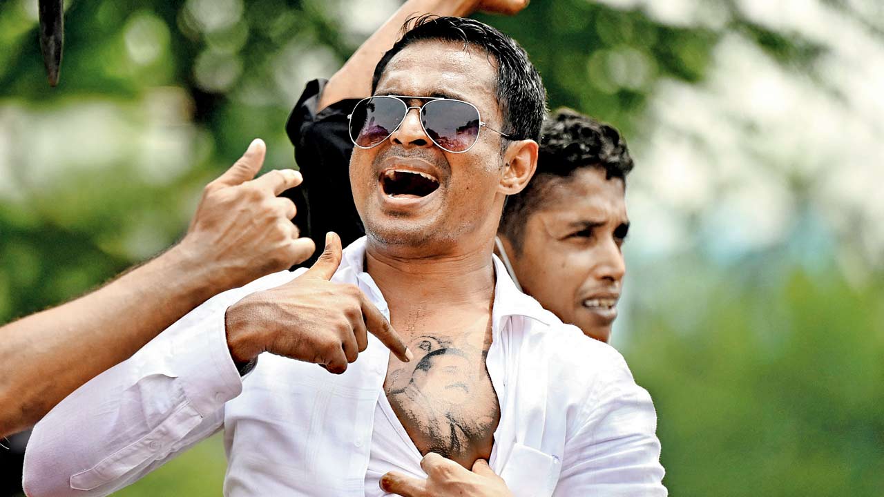 A man shows a tattoo on his chest of Rajapaksa