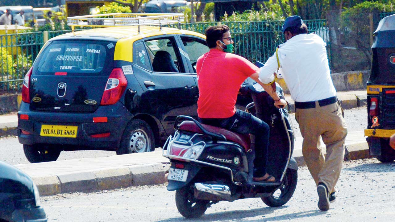 A traffic policeman chases a biker without a helmet, outside LTT, Kurla, on February 7. Pic/Sayyed Sameer Abedi