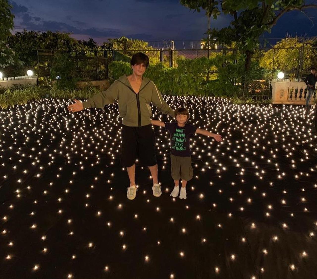 Shah Rukh Khan, AbRam Khan strike the former's iconic pose of spreading arms in this luminous click surrounded by lights that make this a stunning picture.