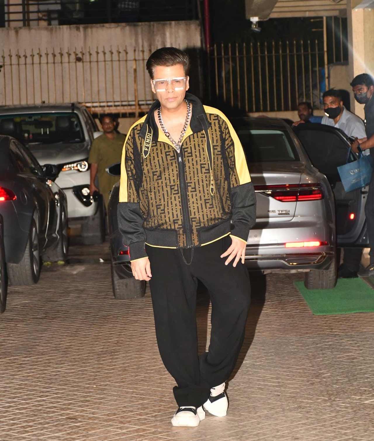 Karan Johar posed for the paparazzi as he arrived at Karisma Kapoor's residence for a dinner outing.