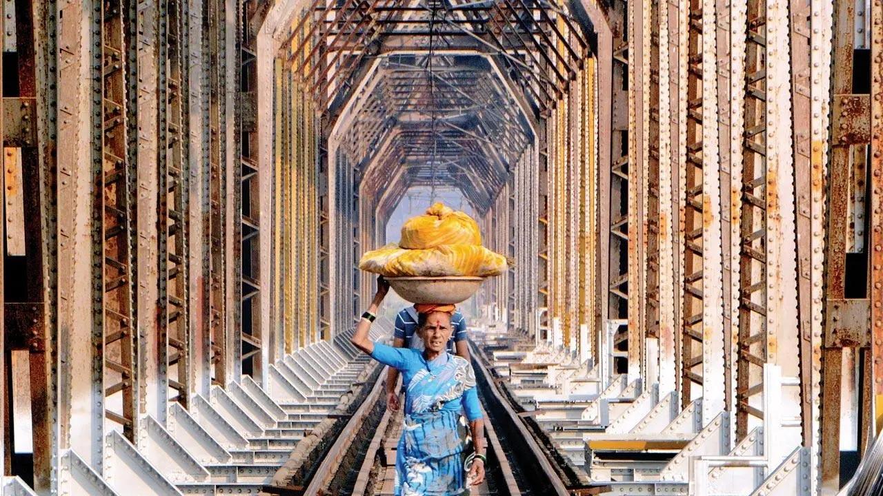 Walking a thin line: A woman carries a basket through the vaulted towers of a railway bridge over Ulhas River near Dombivli. Pic/Satej Shinde