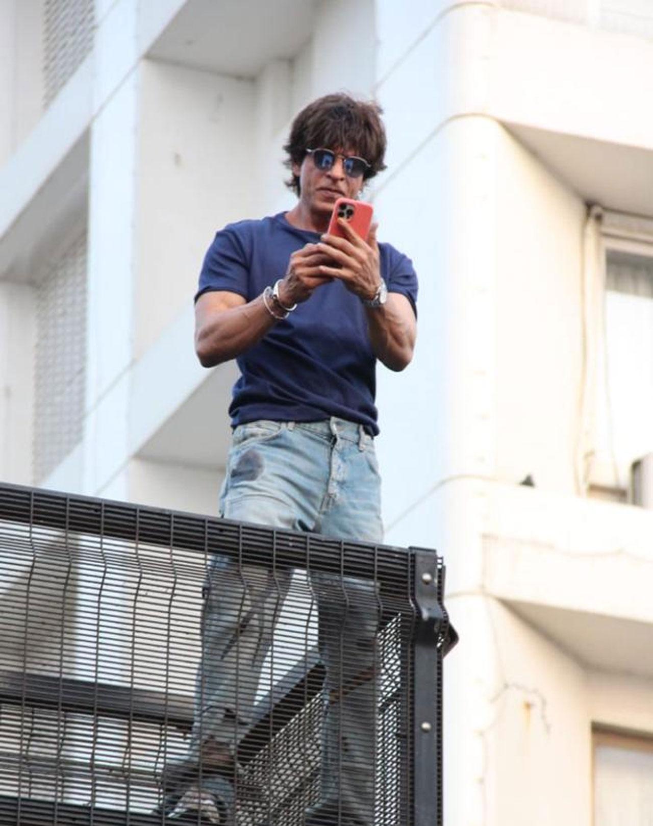 Shah Rukh Khan too came out at the balcony of Mannat after what felt like ages in a clean shaven look. He was recording the video on his phone. Both the Khans twinned in blue. 