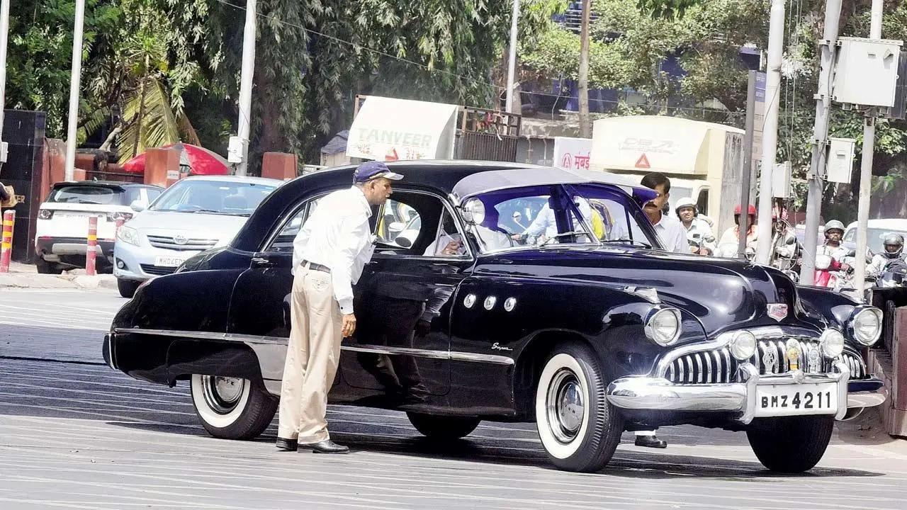 The Past and the curious: A traffic police constable peeks inside a vintage car at Kemps Corner. Pic/Shadab Khan