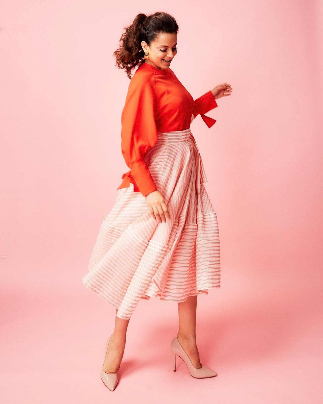 Doesn't this look like a sweet summer breeze? Kangana Ranaut, for one of the events, was seen wearing a tangerine top, paired with a retro-inspired stripe skirt, paired with a high ponytail. 