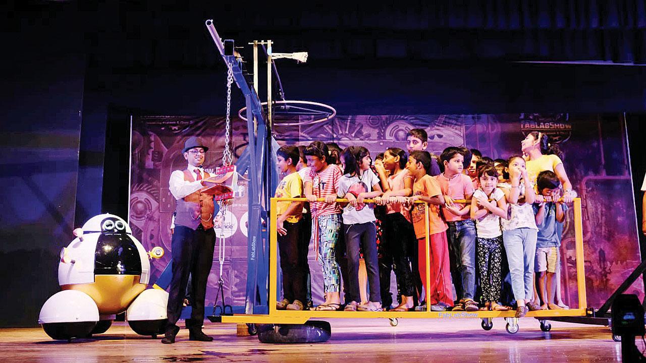 Chip and Prateek Dhruva conduct experiments with a group of kids