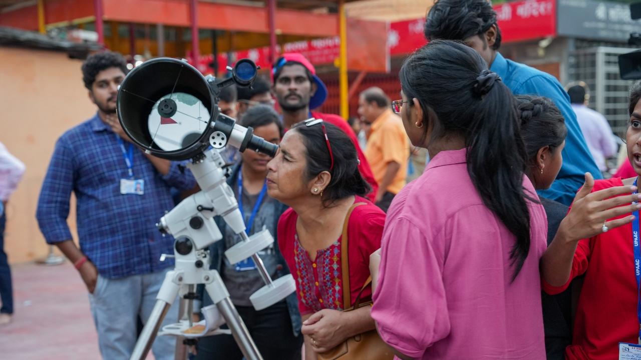 A woman looks through a telescope to watch the total Lunar Eclipse in Lucknow, Uttar Pradesh. Pic/ PTI
