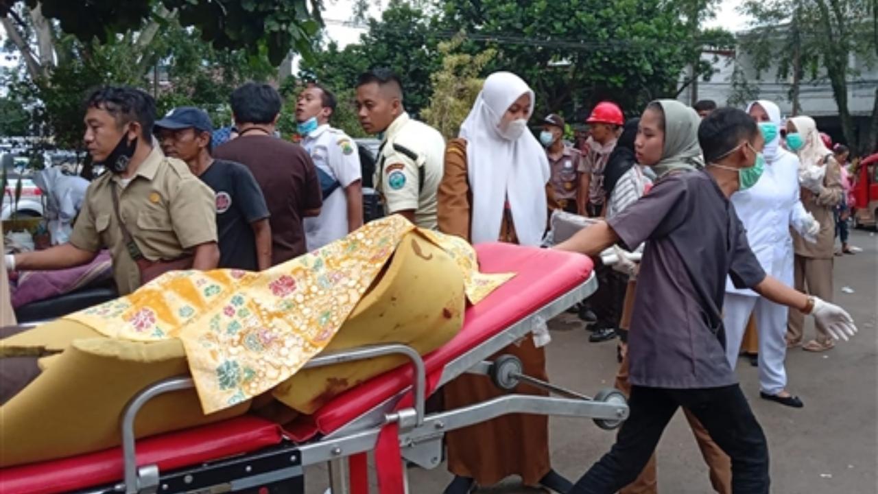 A hospital worker carries an earthquake victim on a gurney outside a hospital in Cianjur