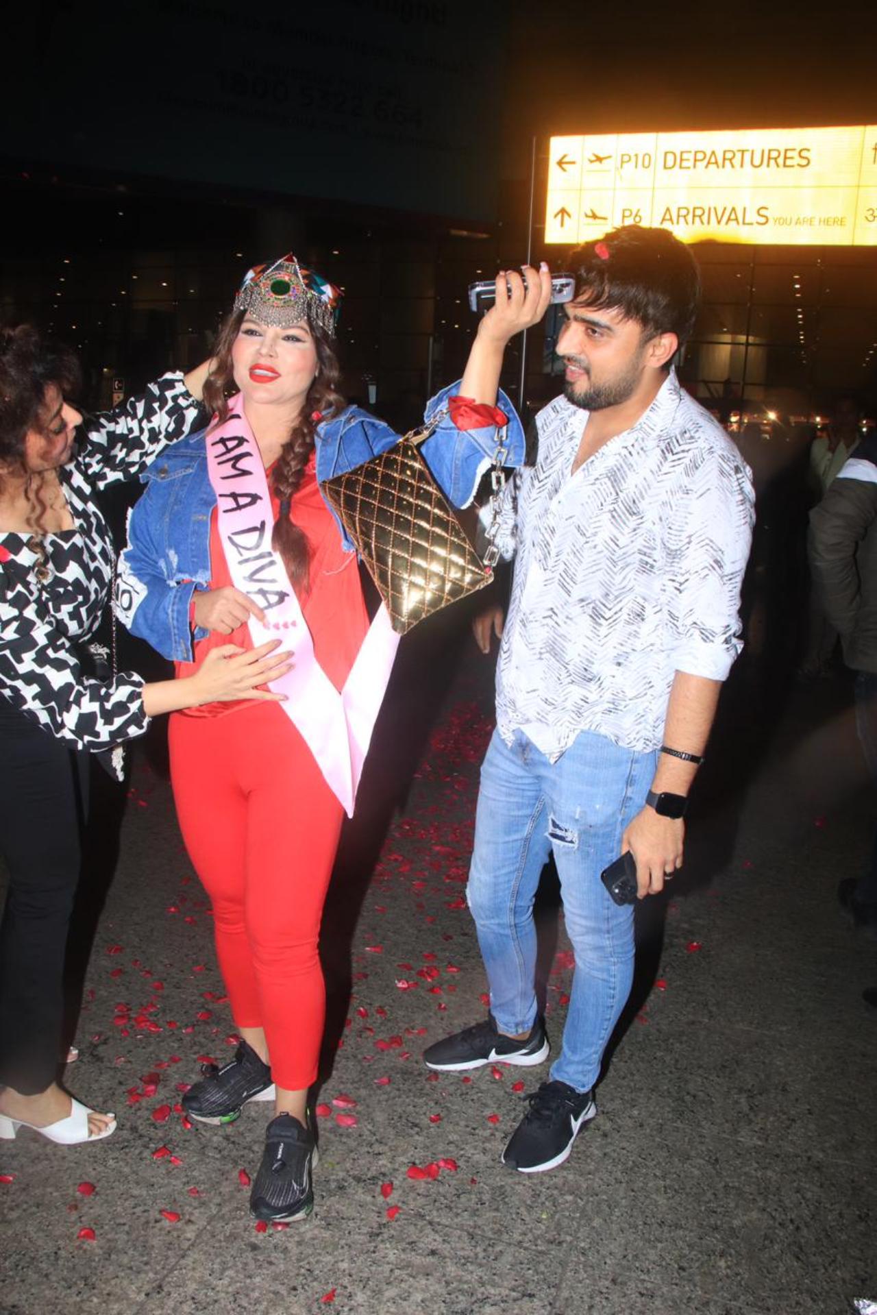 With red rose petals showered on her, Rakhi walked on the premise outside the airport with boyfriend Adil Khan by her side
