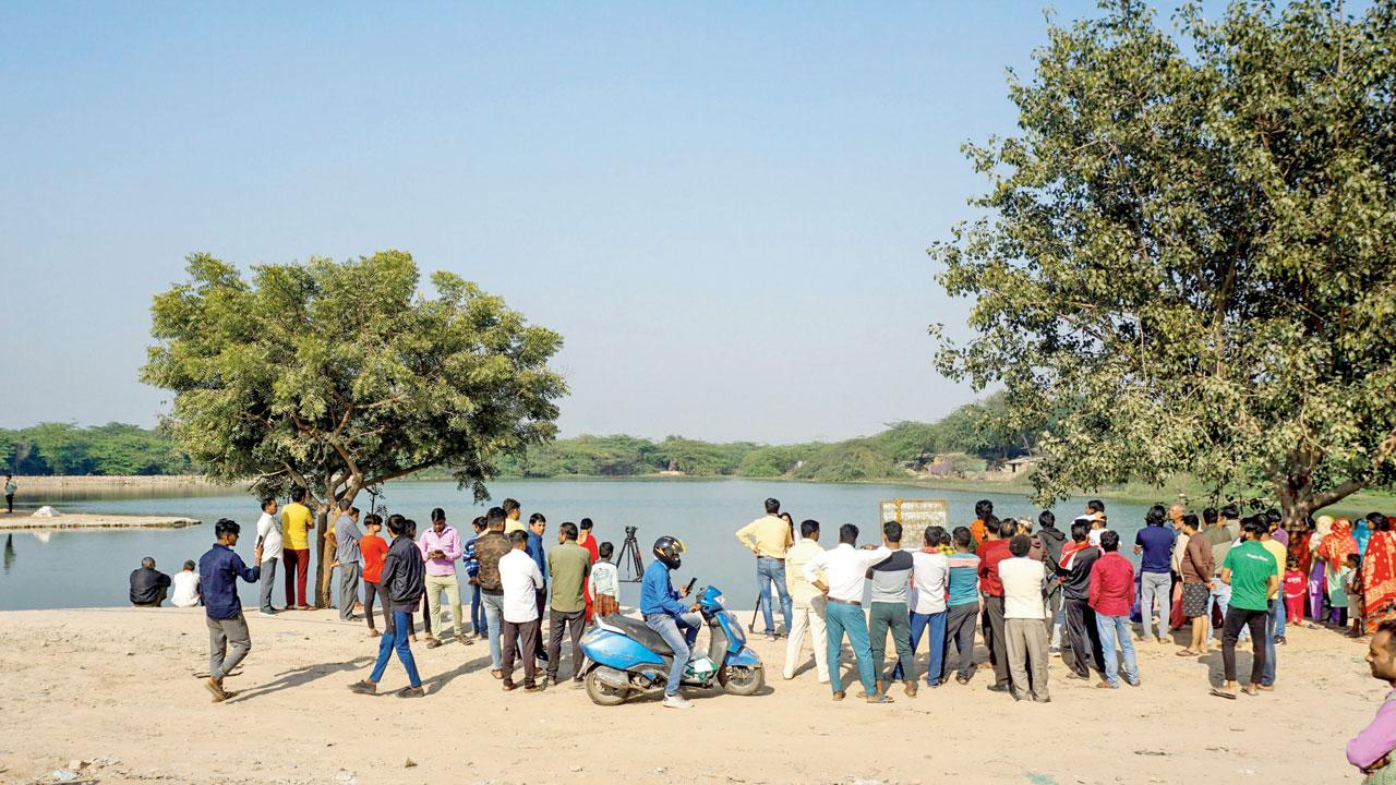 Mediapersons and locals near a pond where Poonawala is suspected to have dumped Walkar’s body parts, at Chhatarpur in New Delhi, on November 21. File pic