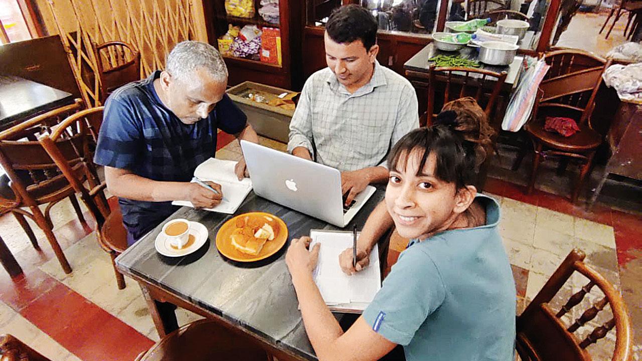 Yuki Ellias (right) writing at the Cafe De La Paix in Girgaum