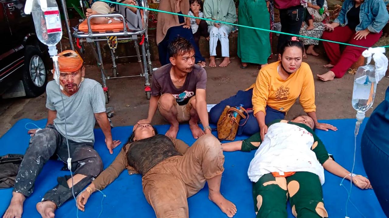 People injured during an earthquake receive medical treatment in a hospital parking lot in Cianjur