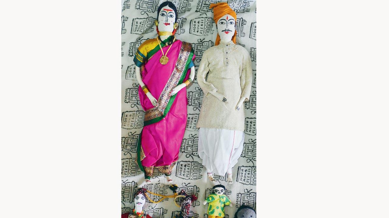 A pair of Maharashtrian cloth dolls, where the woman is wearing a nauvari saree