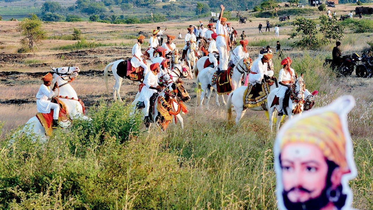 Men dressed in traditional attire arrive on horseback to welcome Gandhi