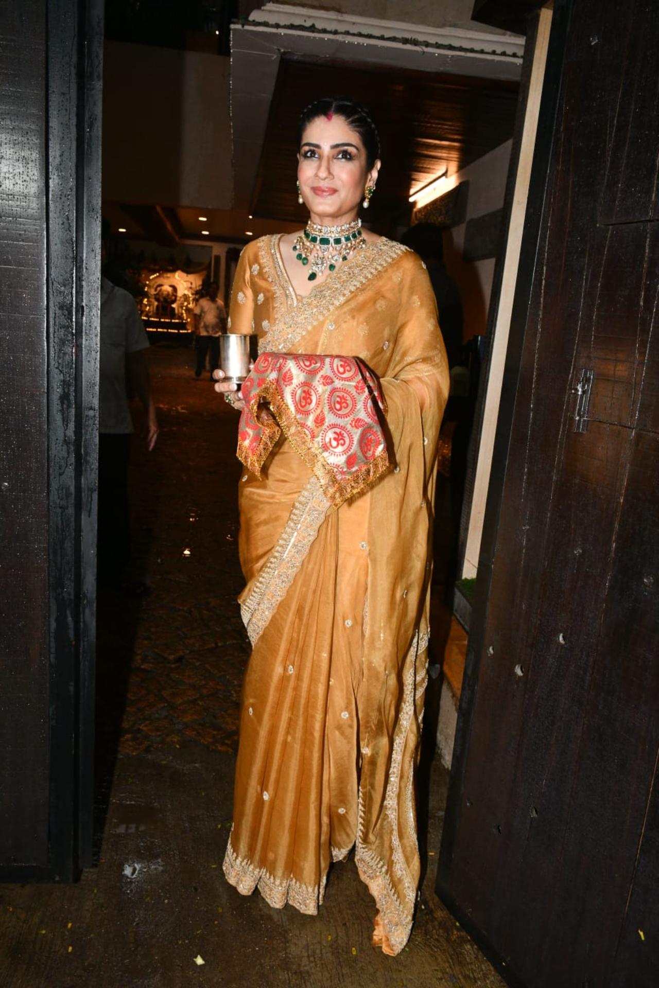 Raveena Tandon looked gorgeous in shiny golden saree paired with an emerald studded necklace