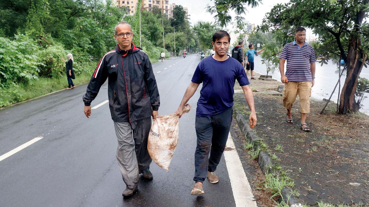 Jeetendra Rathod (left) carrying soil for plantation with the help of another member