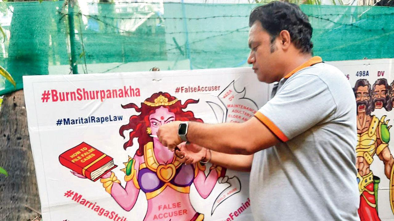 A Vaastav Foundation member cuts of the nose of a Shurpanakha effigy on Dussehra