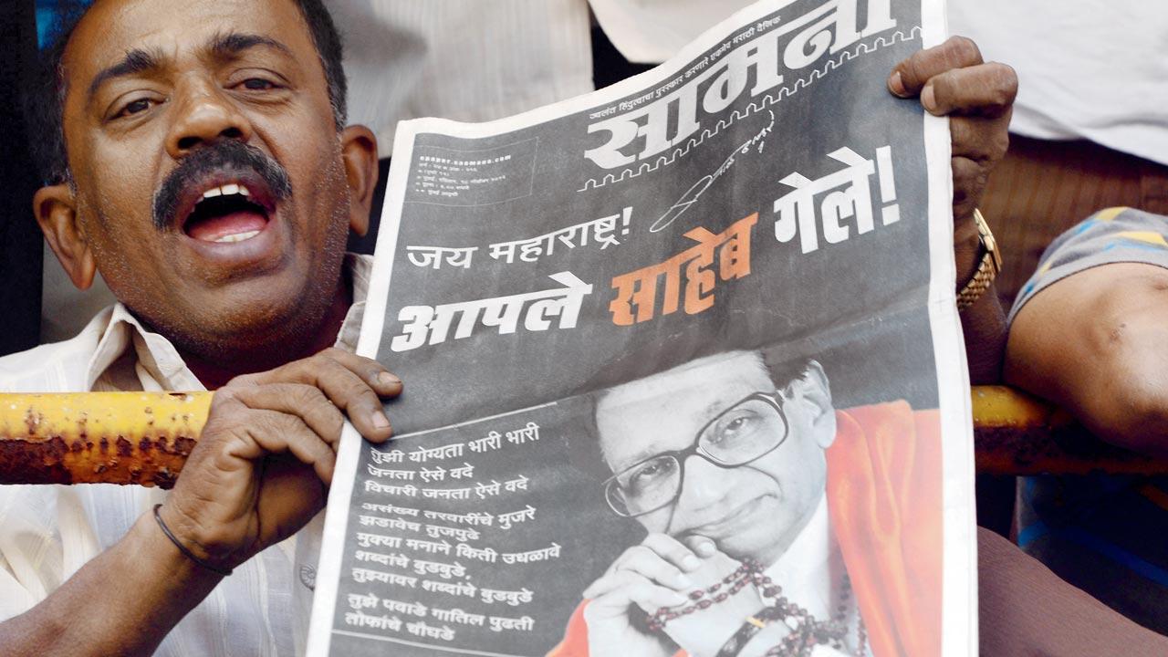 A file picture of supporters reading Saamana with the front page news of the demise of Shiv Sena party supremo Bal Thackeray during his funeral procession on November 18, 2012. Pic/Getty Images