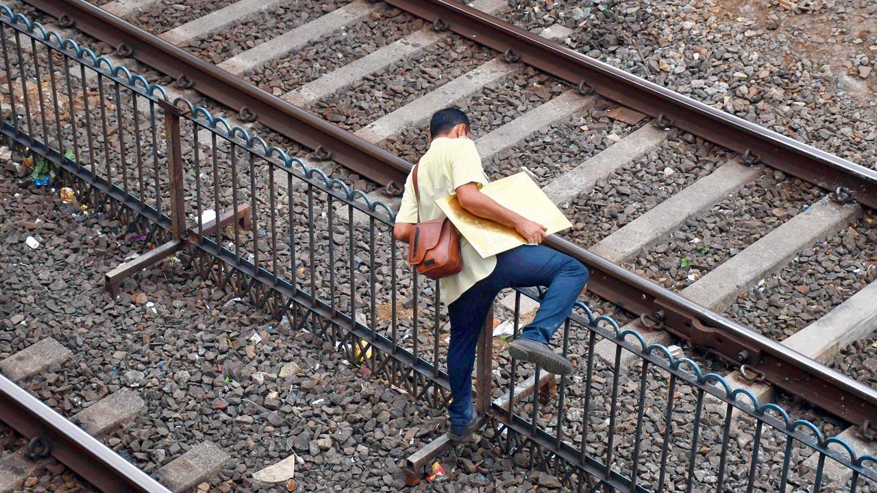 A commuter crosses tracks at Charni Road station on Monday to avoid the bridge at the Churchgate-end