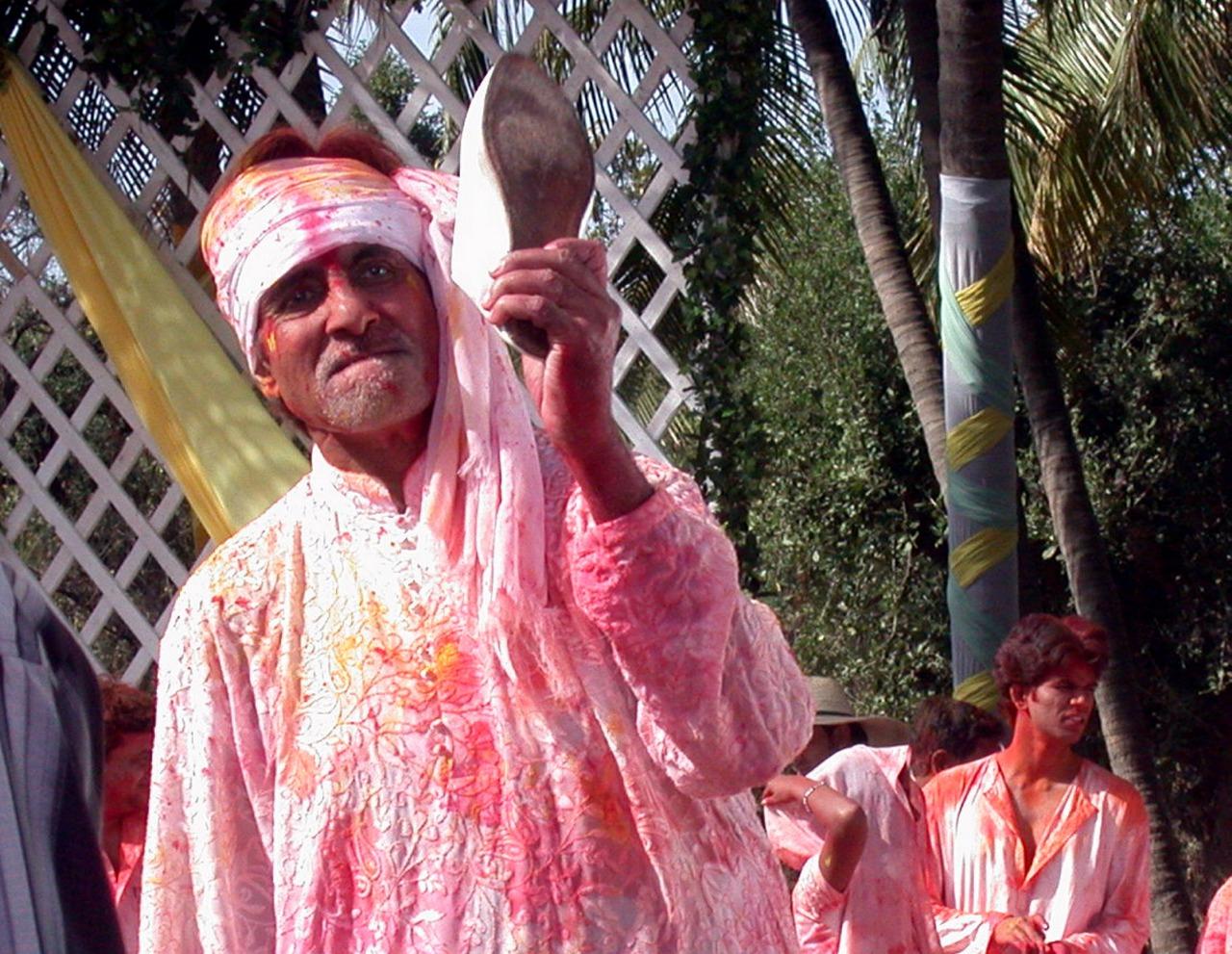 Amitabh Bachchan and the festival of Holi are synonymous with his song, 'Rang Barse' being a festival favourite. Here is a candid picture of the actor during Holi covered in colours and holding a shoe
