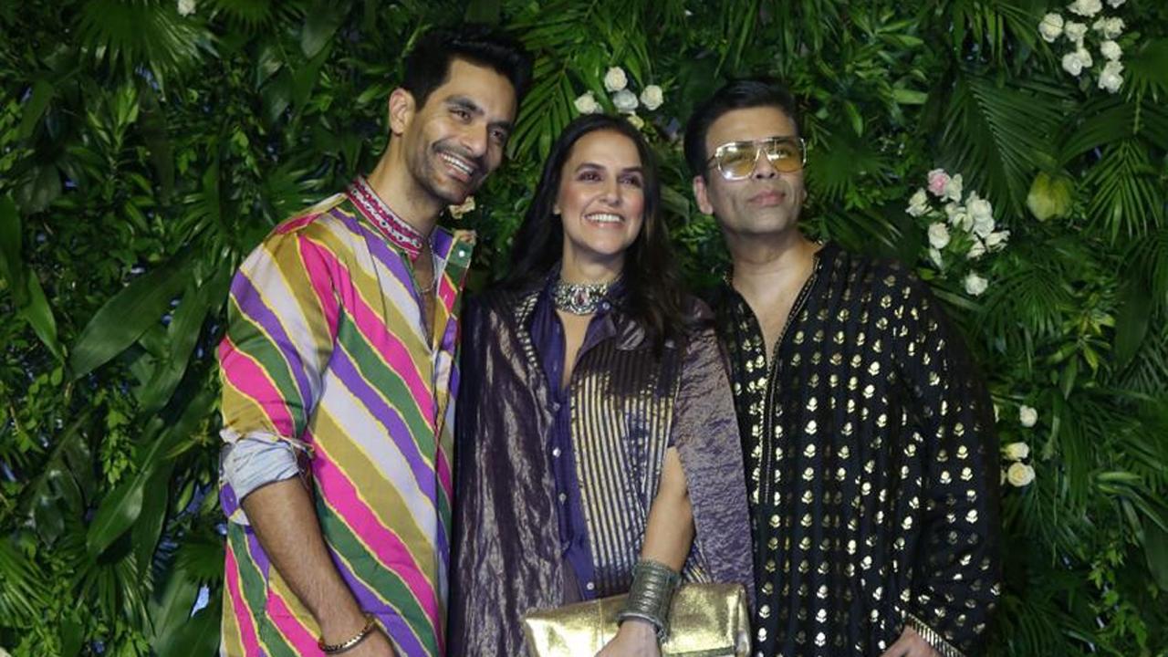 Besties Angad Bedi, Neha Dhupia and Karan Johar walked in together. While Karan opted for black, the couple opted for a riot of colours. 