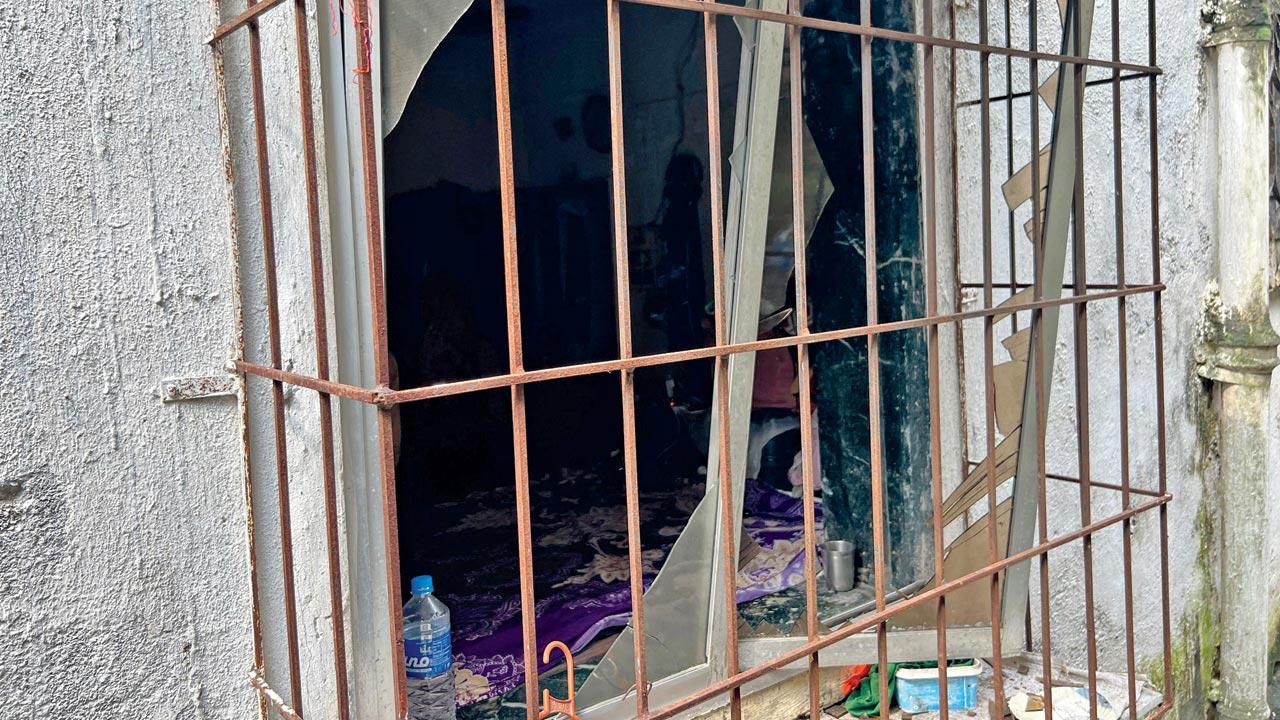 Windowpanes that were shattered due to the blast, money that was lying around in the living room, which was damaged in the blast  Shahnawaz Ansari shows the extent of damage done to his home. 