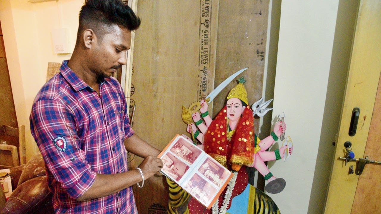 Mahesh Sawant, 24, browses through old photographs of Dadar Paschim Vibhaj Sarvajanik Navratri Utsav Mandal when Marathi and Hindi orchestra, Marathi play and classical music were part of the celebrations. As part of festivities, Bal Thackeray was also made to sit in a dock and answer questions from the community in a friendly spirit