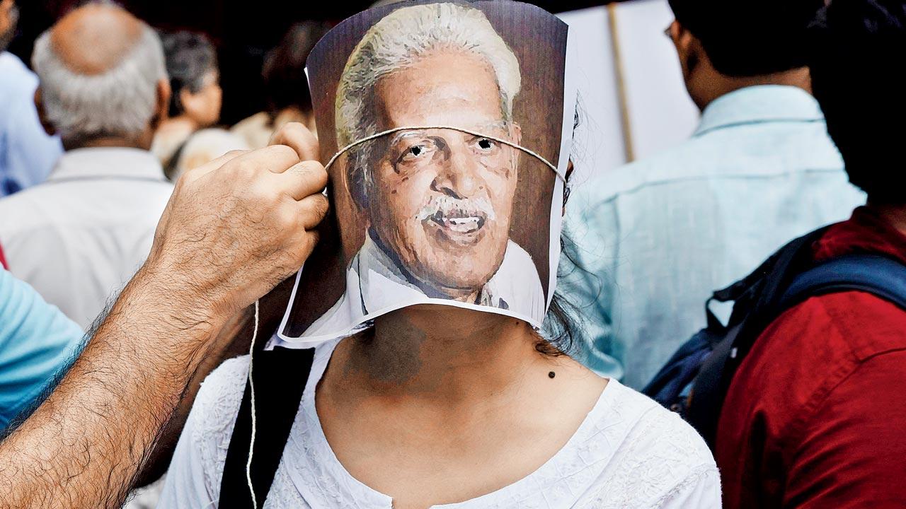 A protester adjusts a portrait of poet-teacher-activist and Elghar Parishad accused Varavara Rao on the face of another protester during a demonstration in New Delhi, following his arrest in 2018. Rao’s advocate Anand Grover had highlighted the dismal conditions inside Taloja Jail, before a division bench of the Bombay High Court, in April this year