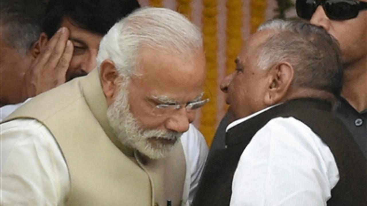 March 19, 2017: Prime Minister Narendra Modi and Samajwadi Party founder Mulayam Singh Yadav exchange warm gestures during the swearing-in ceremony of new Uttar Pradesh government in Lucknow. File Pic/PTI