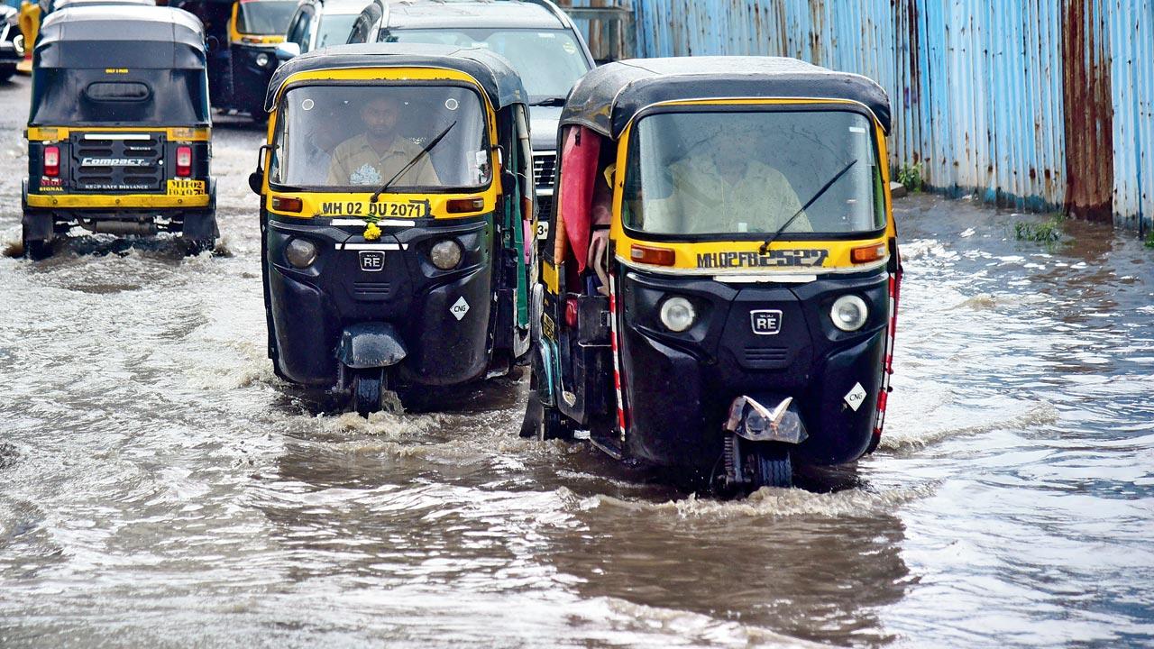 Autos ply on a waterlogged road, at BKC, on Tuesday. Pic/Shadab Khan