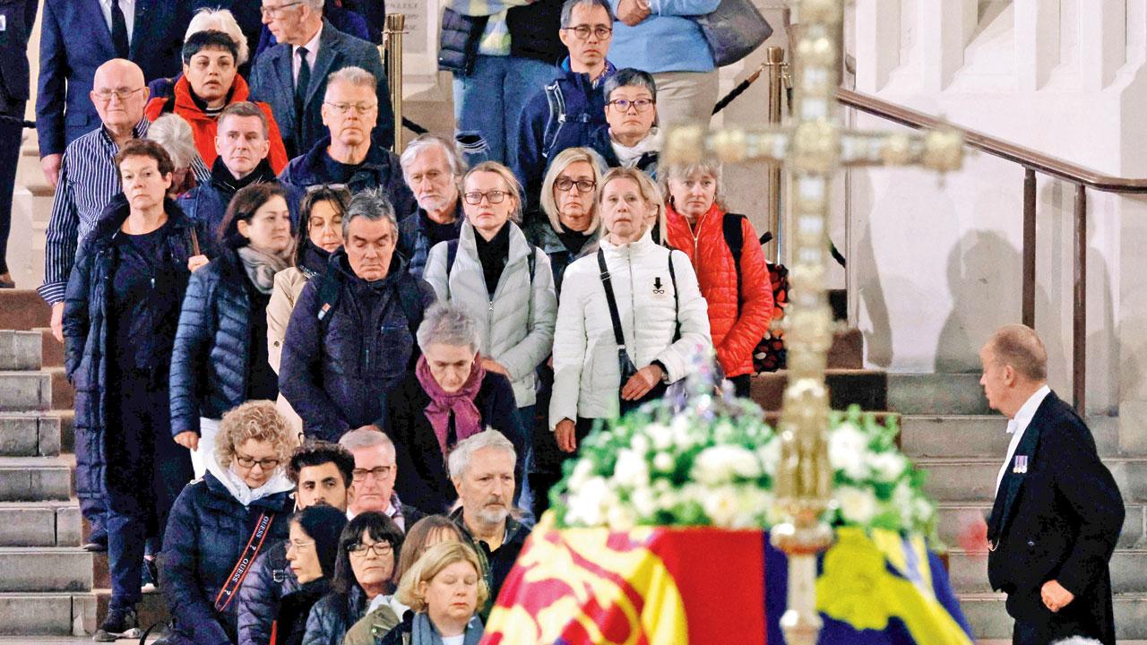 Visitors get their first glimpse of Queen Elizabeth II’s flag-draped casket lying in state on the catafalque as they enter Westminster Hall on Saturday. Pic/AFP