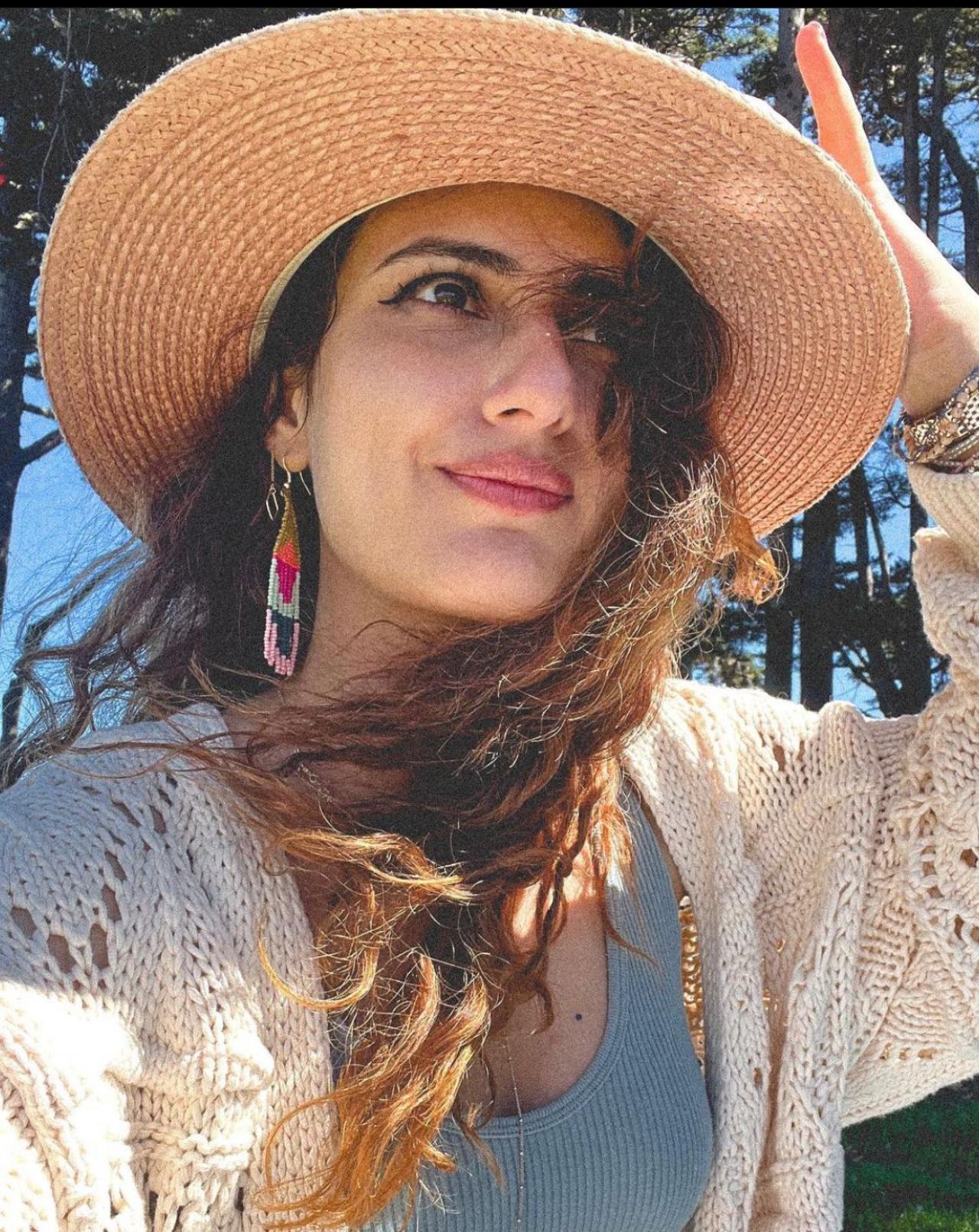 In her first look, Fatima Sana Shaikh's outfit features a ribbed low-neck top, a baggy knitted vintage sweater, and a jute sun hat. She kept her look simple yet very stylish and engaging