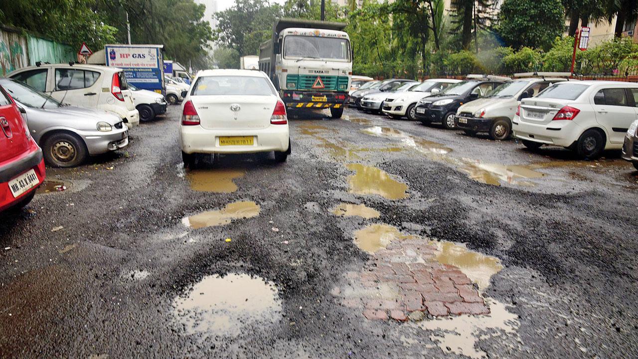 Huge potholes cover the road near Pratiksha Nagar bus depot. Pic/Atul Kamble