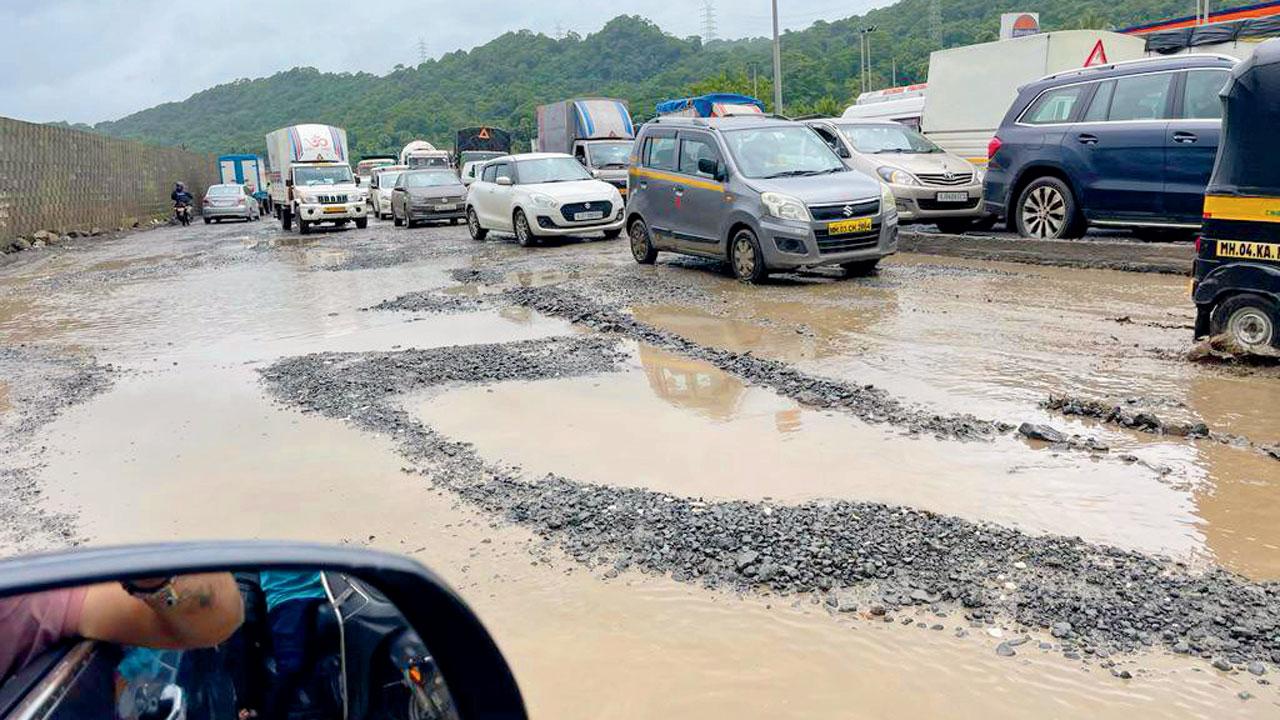 Potholes dot the road near the Versova bridge
