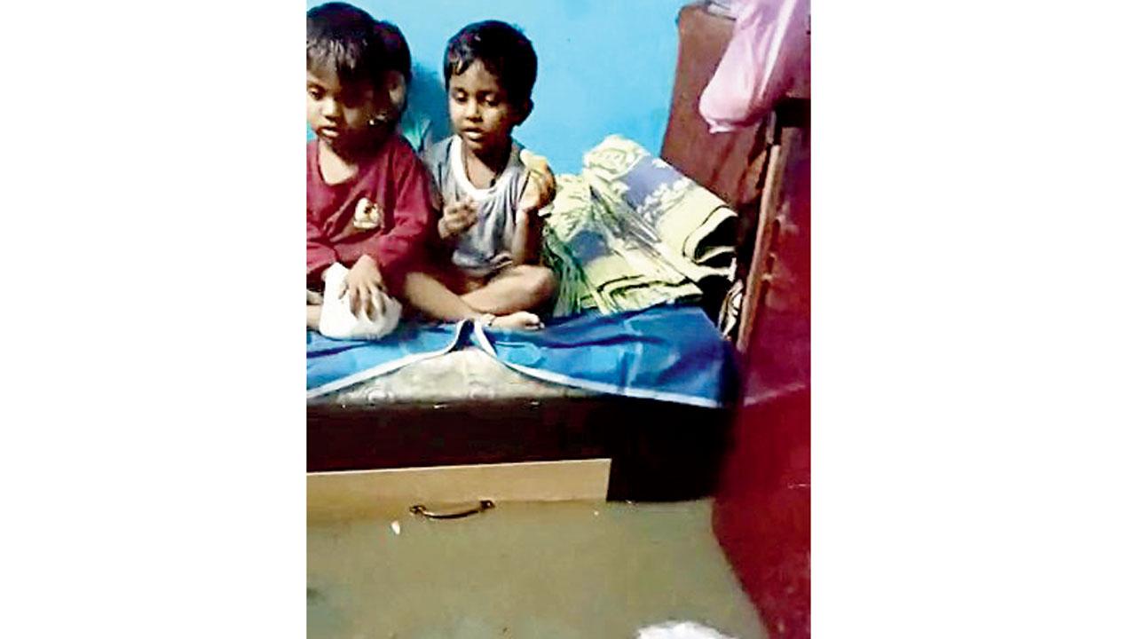 Children sit on a bed, as flood water enters their home. PIC/ANI 