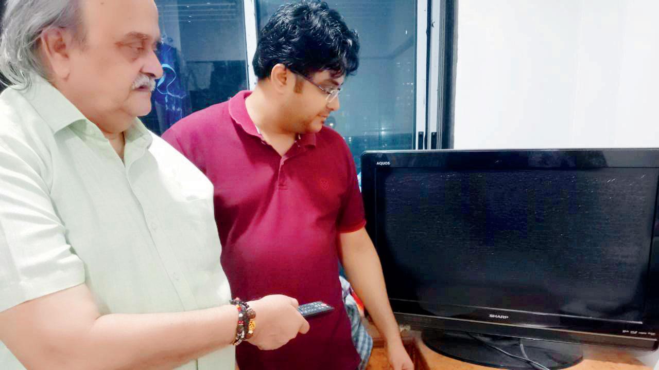 Dhananjay Desai (left) and his damaged television set