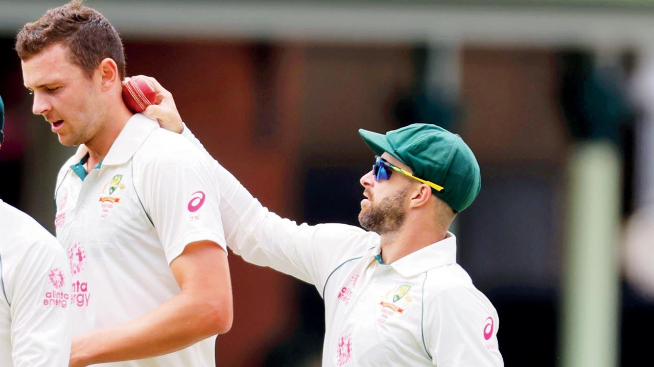Australia’s wicketkeeper Matthew Wade (right) uses the sweat on Josh Hazlewood’s neck during the third Test against India at Sydney last year