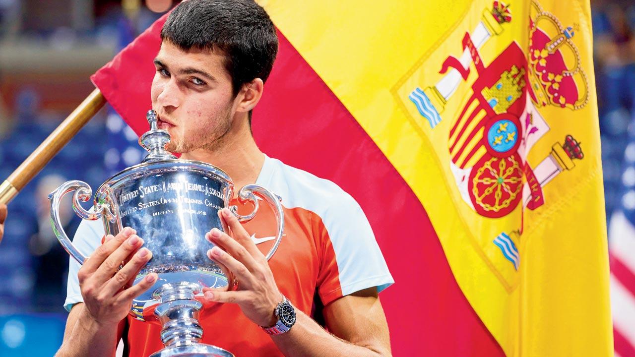 Carlos Alcaraz kisses his US Open winner’s trophy