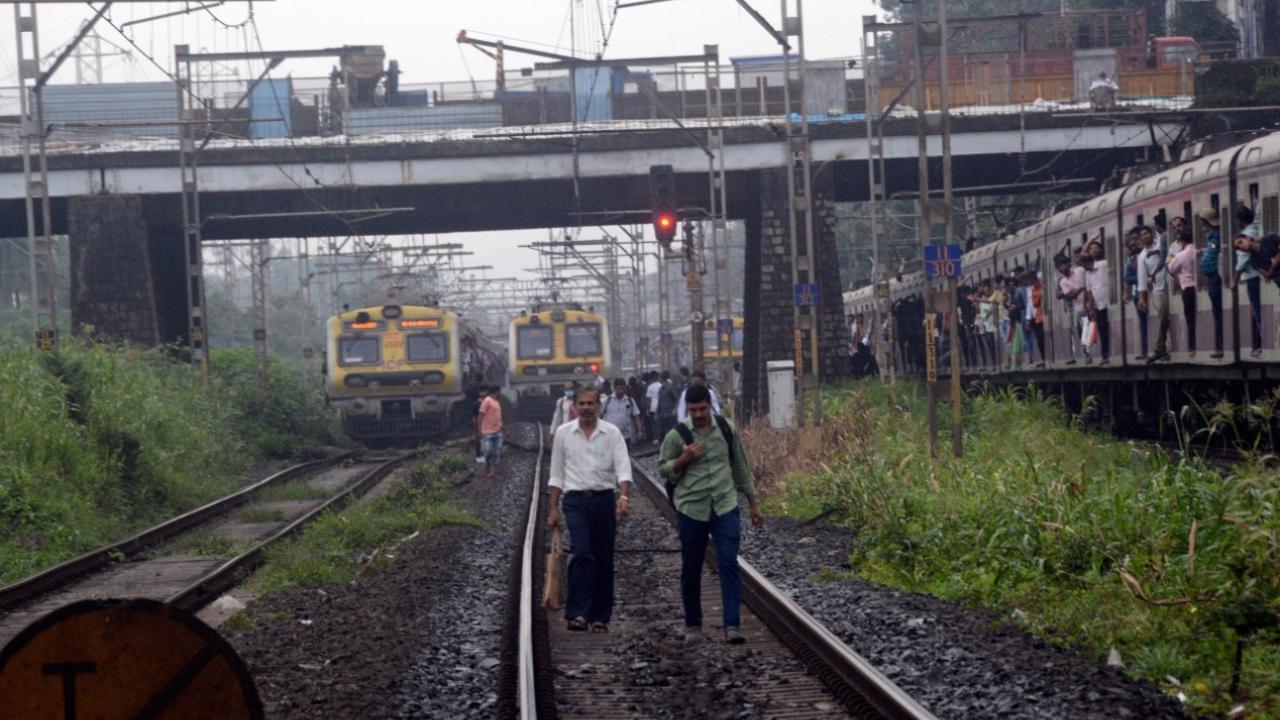 Commuters seen walking on tracks between Sion and Matunga railway station, due to signal problem between Dadar and Parel railway station on fast track