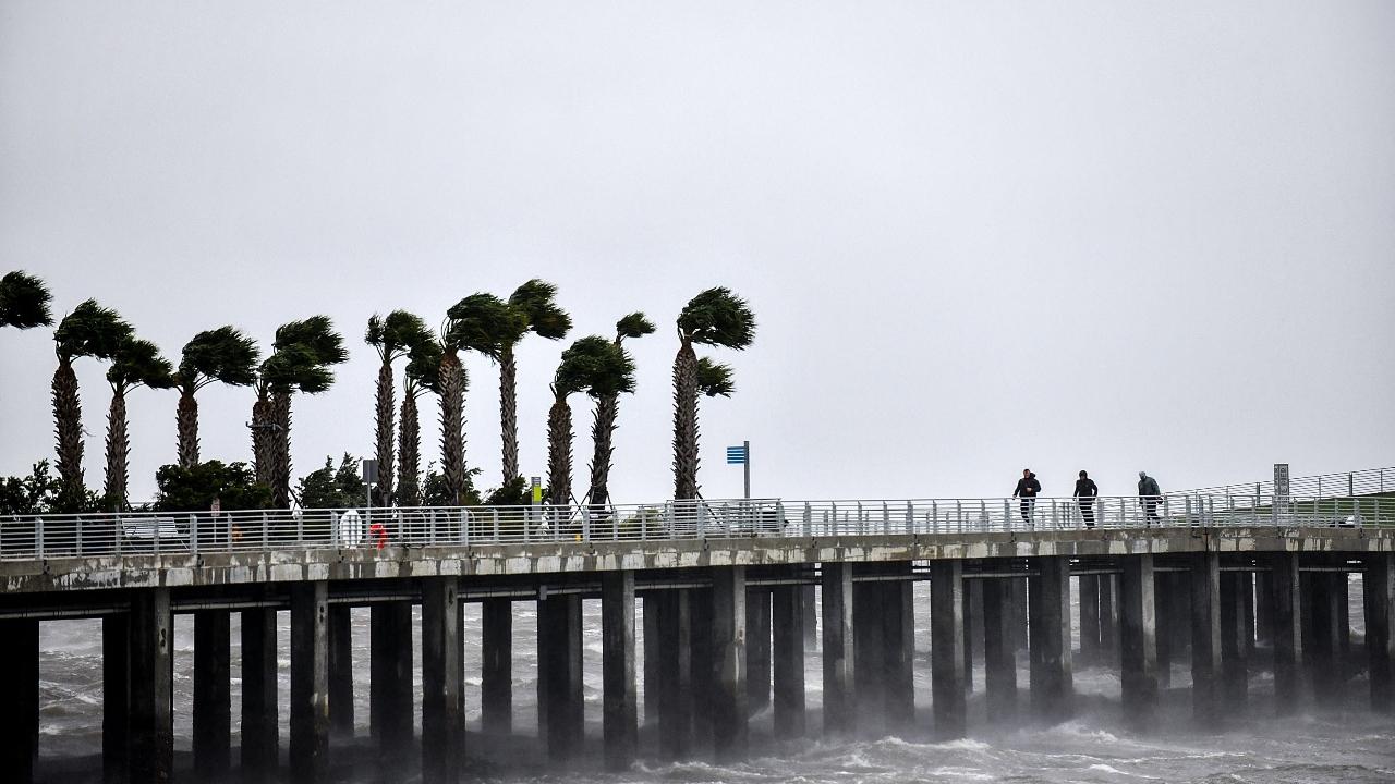Local residents walk in the middle of rain and heavy wind at the St. Pete pier as the Hurricane Ian hits the west coast. Pic/AFP