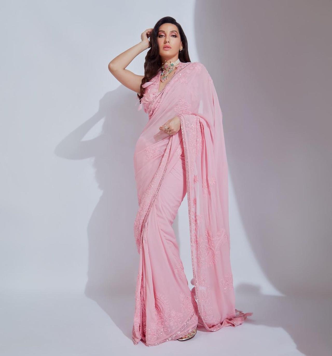 Nora looked dreamy in this baby pink coloured saree with feather design on the blouse. She completed the look with a choker necklace, shimmery make-up with pink eyeshadow